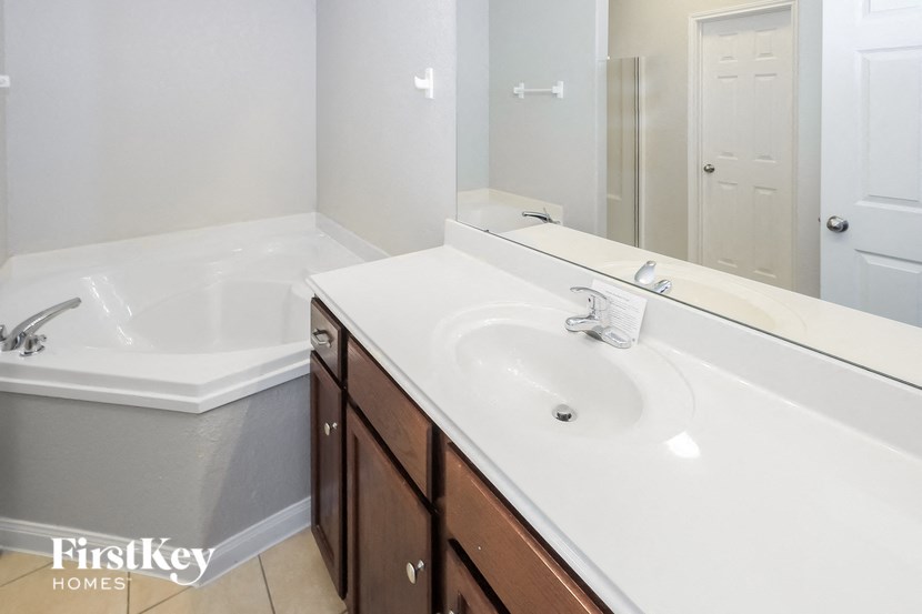 a bathroom with a sink and a tub and a mirror