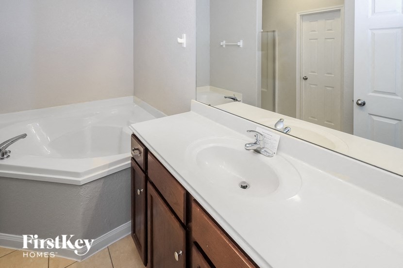 a bathroom with a sink and a tub and a mirror