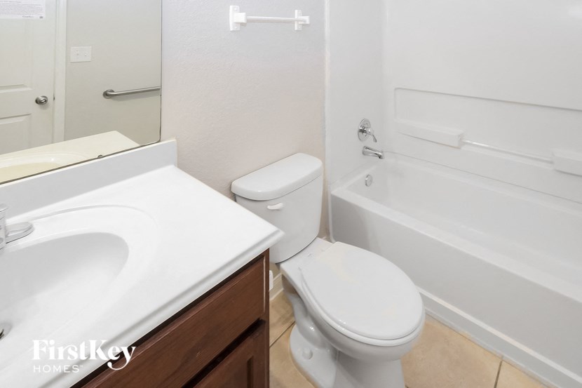 a bathroom with a toilet and a tub and a sink