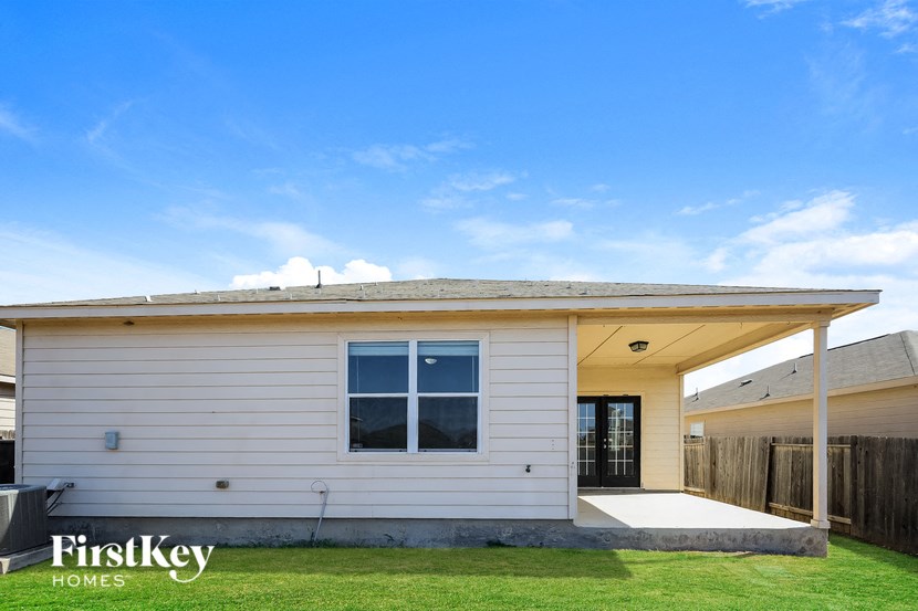 the exterior of a white house with a porch