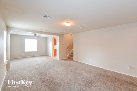 a living room with carpet and a staircase in a house