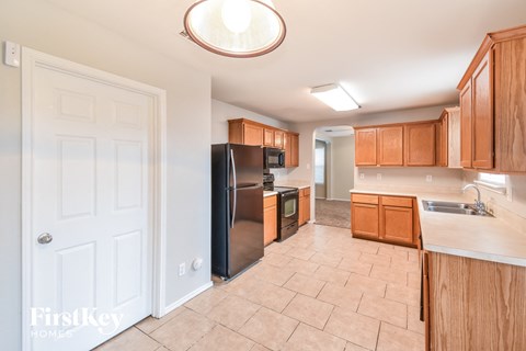 a kitchen with wooden cabinets and a stainless steel refrigerator