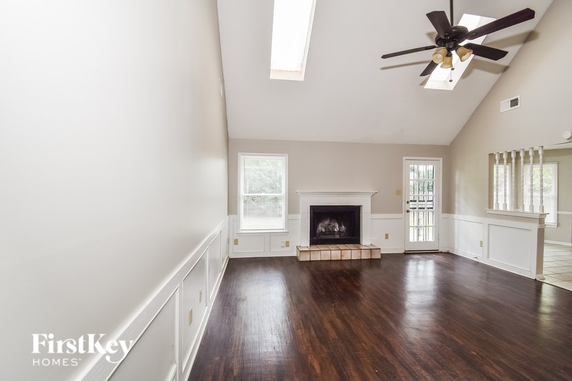 A spacious room with a fireplace and a ceiling fan.