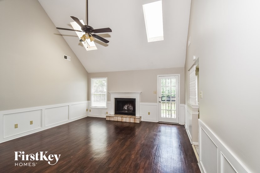 A spacious room with a fireplace and a ceiling fan.