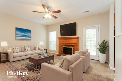 A living room with a fireplace and a television on the wall.