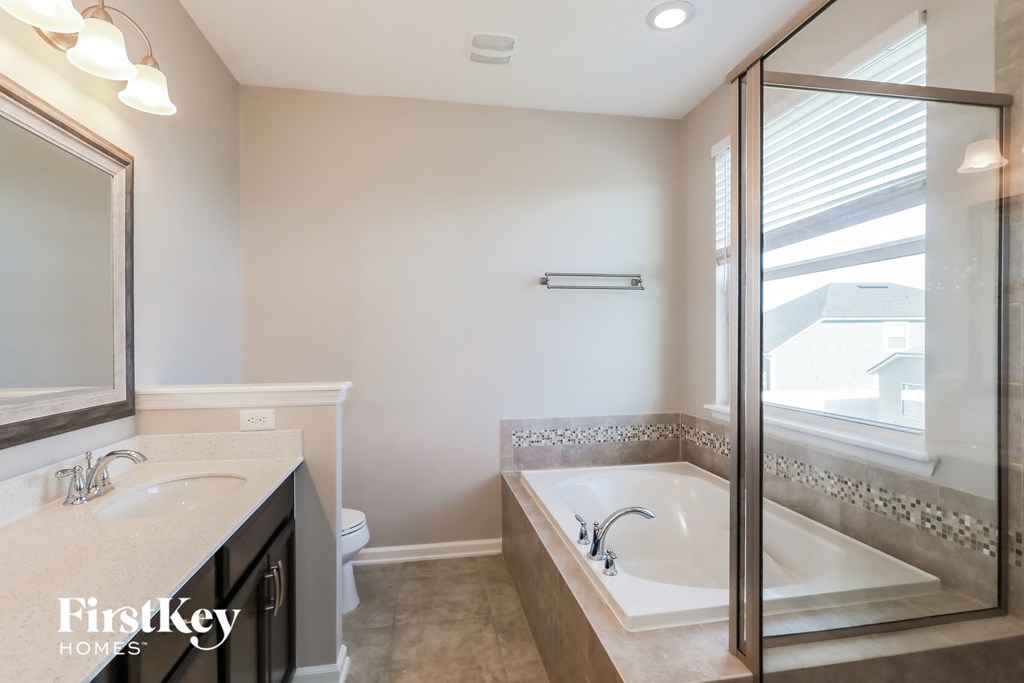 a bathroom with a tub and a sink and a mirror
