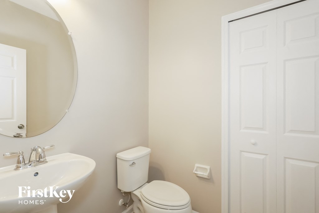 a white bathroom with a mirror and a toilet and a sink