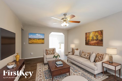 A living room with a couch, a coffee table, and a painting on the wall.