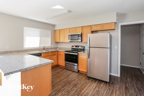 a kitchen with wood flooring and stainless steel appliances