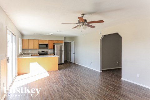 A kitchen with a refrigerator, microwave, and oven is shown in this image.