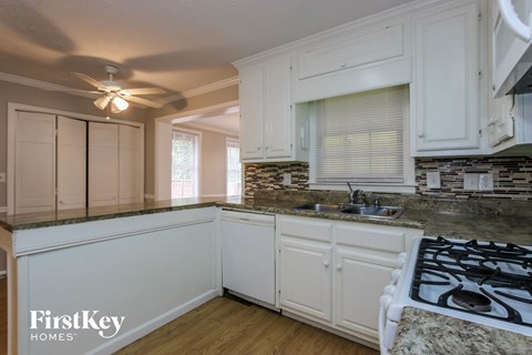 a kitchen with white cabinets and a stove and a sink