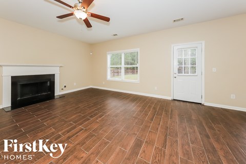 the living room with wood floors and a fireplace