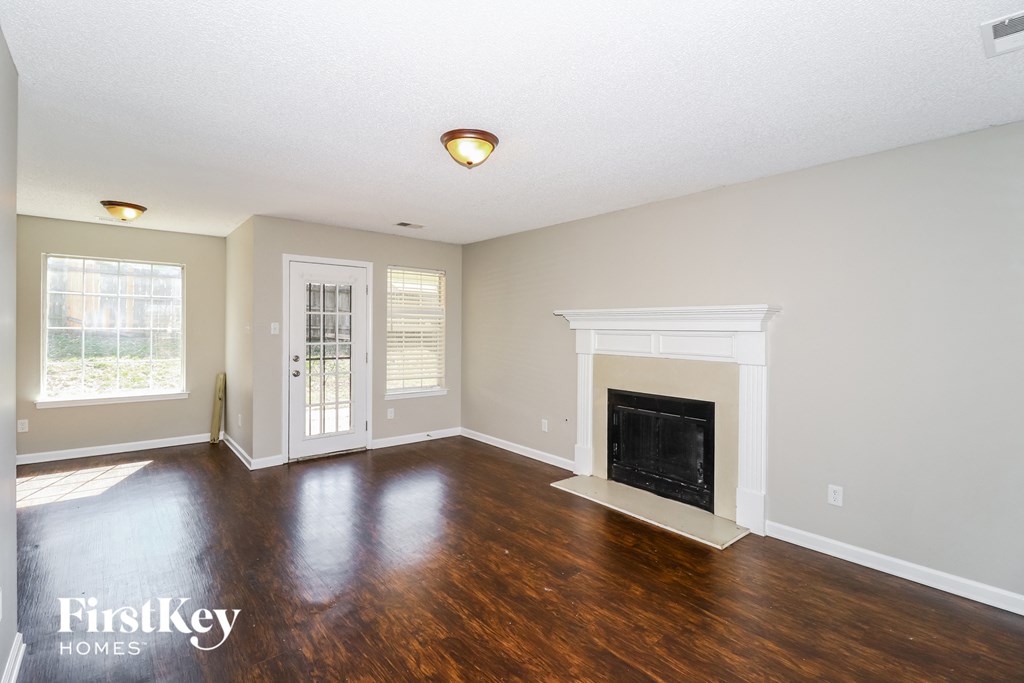 A spacious living room with a fireplace and a sliding glass door.