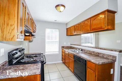 A kitchen with wooden cabinets and a granite countertop.
