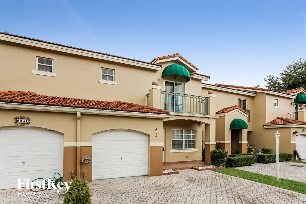 a house with two garages and two white garage doors