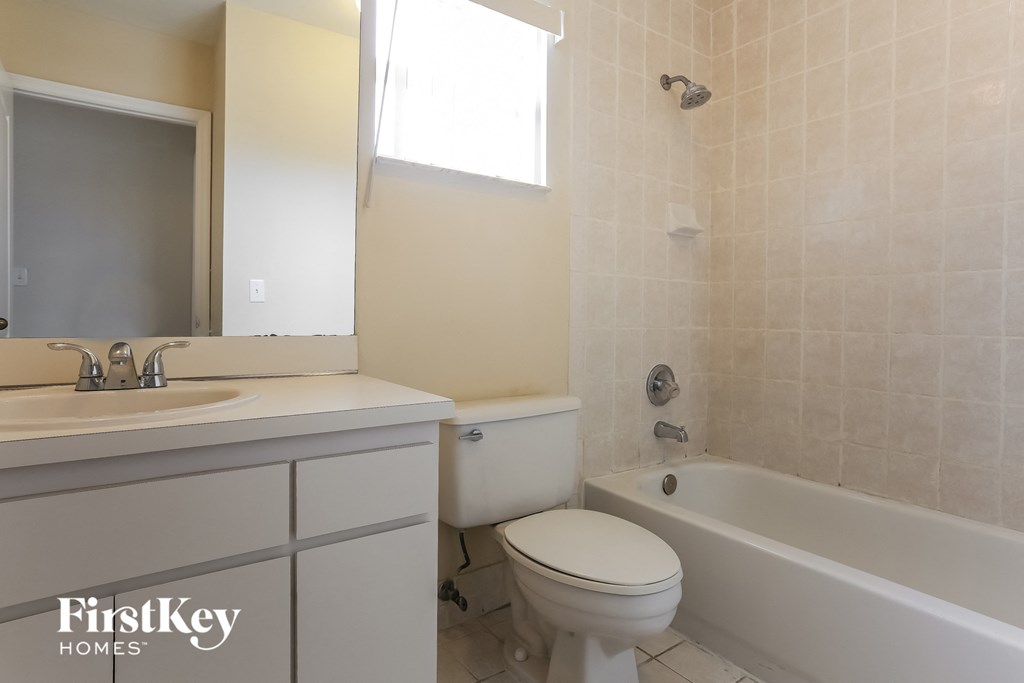 a bathroom with a toilet and a tub and a sink