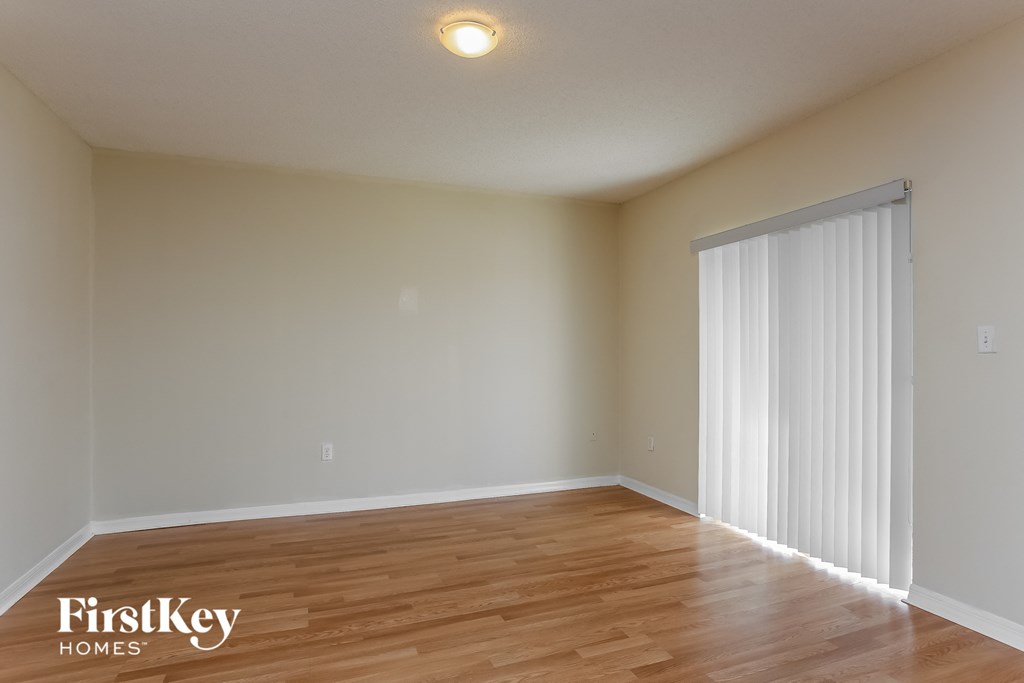 the spacious living room with sliding glass door to the dining room
