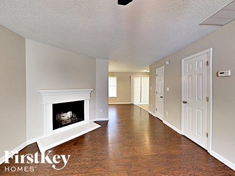 a living room with a fireplace and a hallway with a door