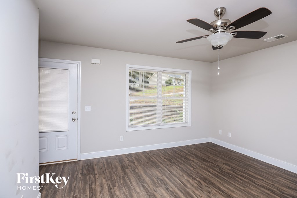 a living room with a ceiling fan and a window