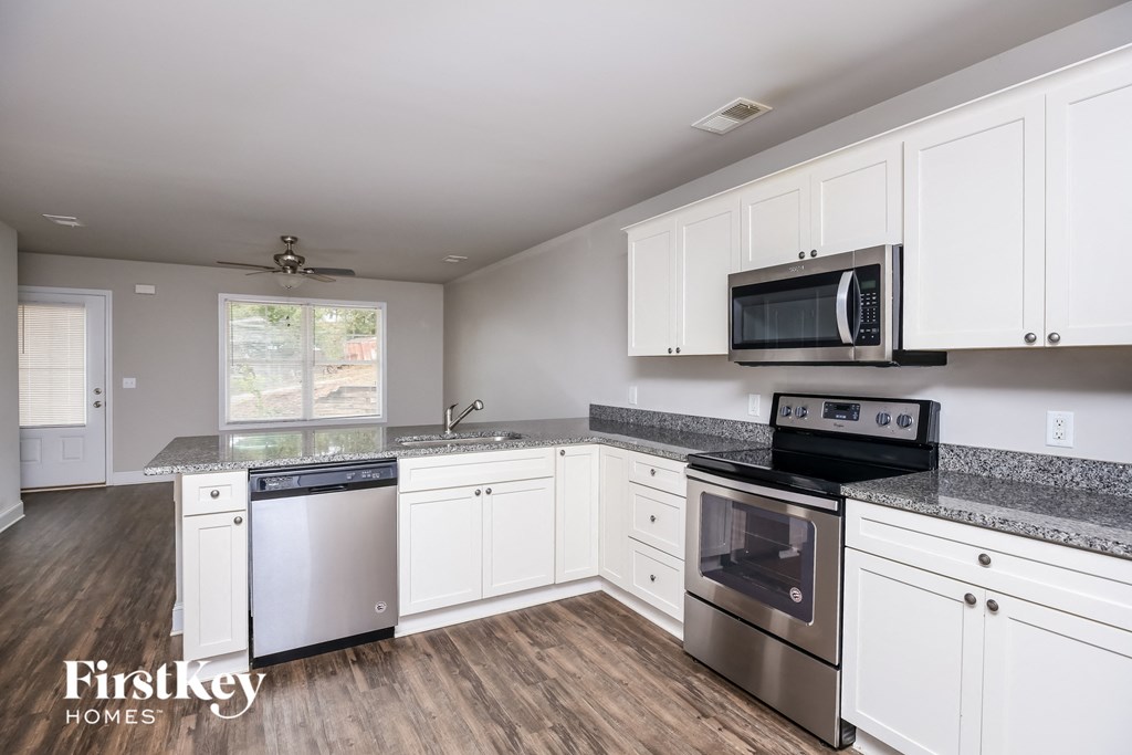 a kitchen with white cabinets and stainless steel appliances