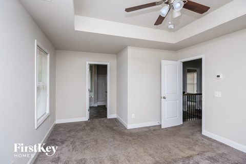 a living room with carpet and a ceiling fan