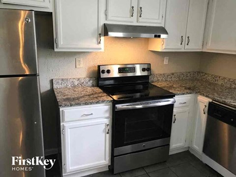 A kitchen with a stove top oven and a refrigerator.