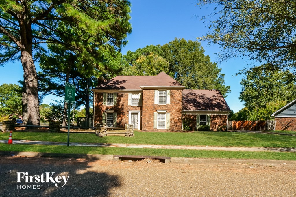 A brick house with a tree in front of it.