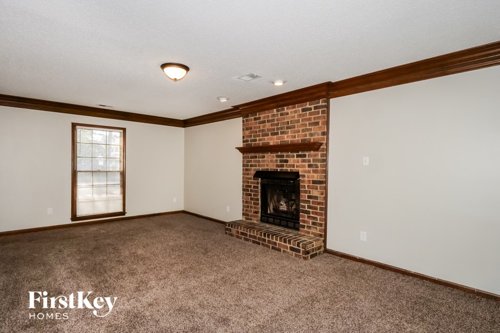 A room with a fireplace and a window.