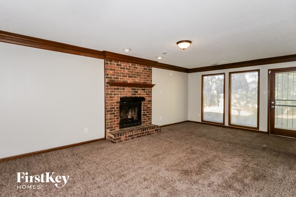 A room with a fireplace and a carpeted floor.