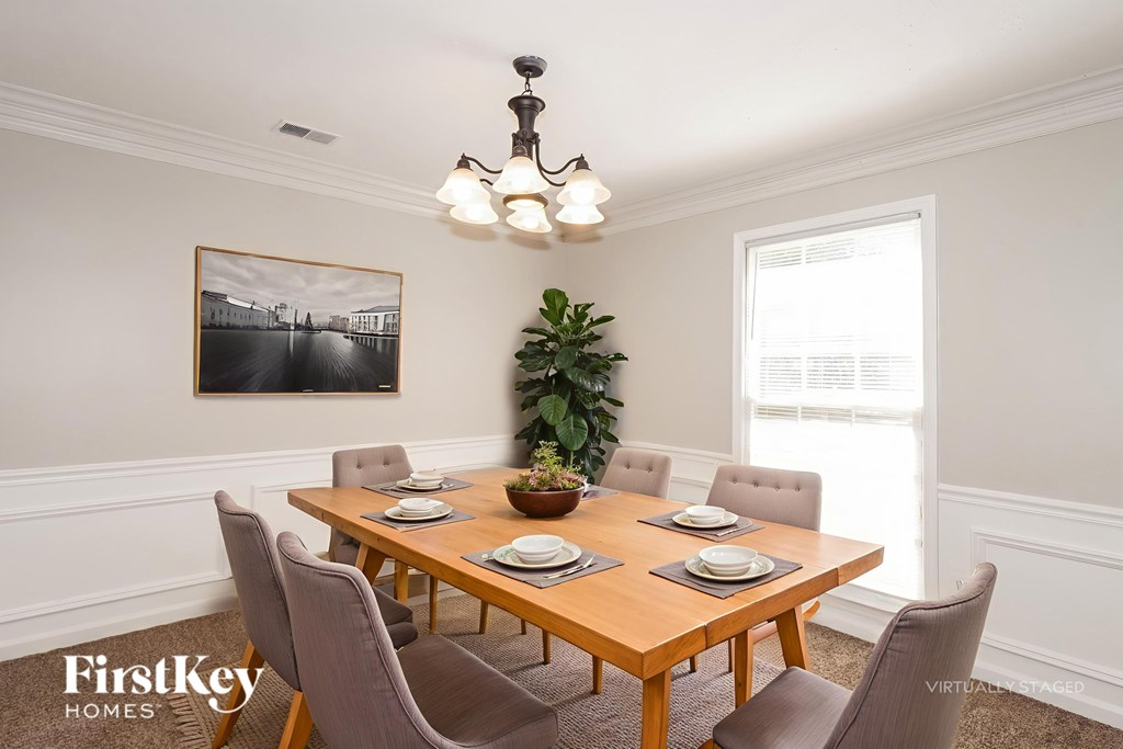 A dining room with a wooden table and chairs.
