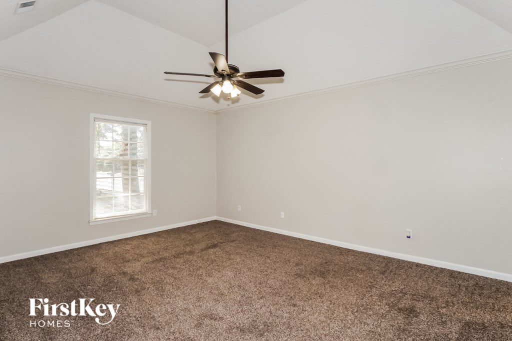 A room with a ceiling fan and a window.