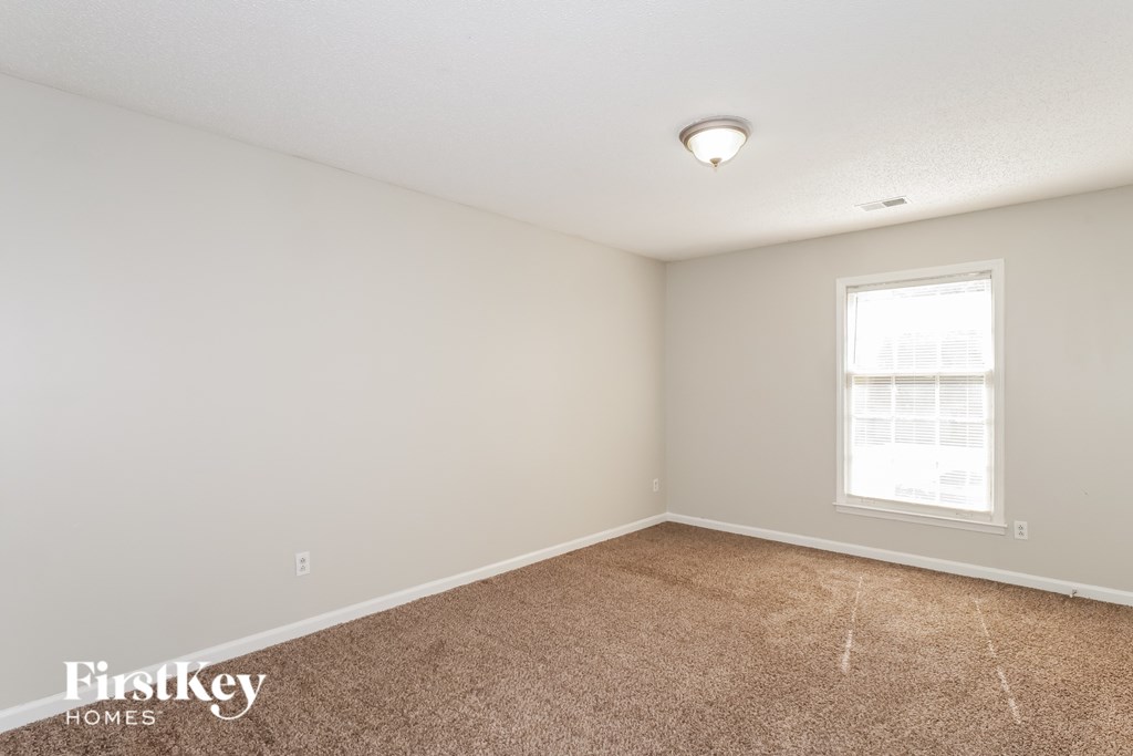 A room with a carpeted floor and a window.