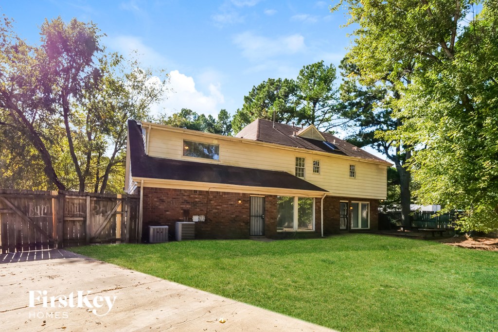 A house with a fence and trees in the background.