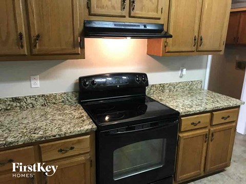 A black oven is on a granite countertop in a kitchen.