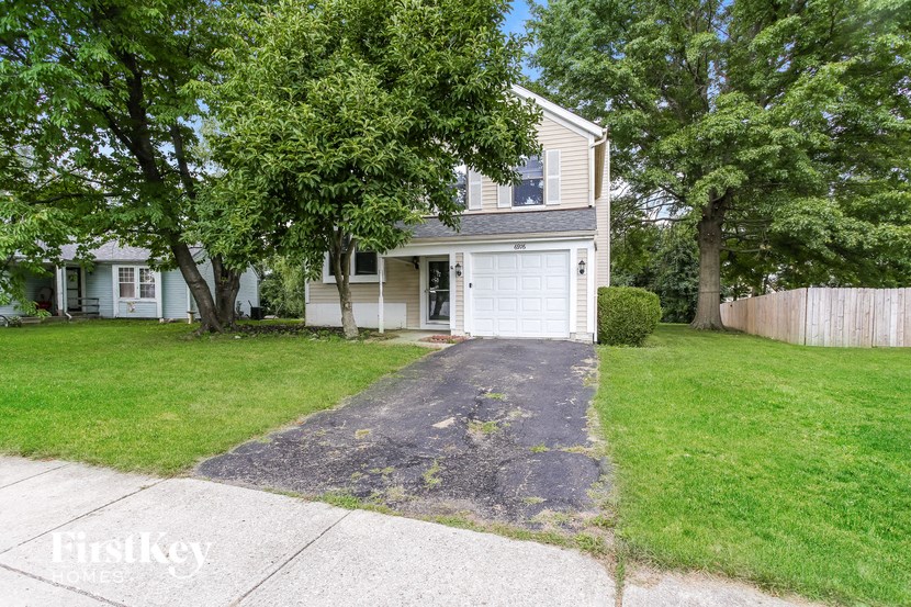 a white house with a driveway and a white garage door