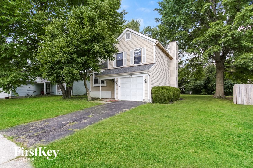 a white house with a white garage door and a lawn