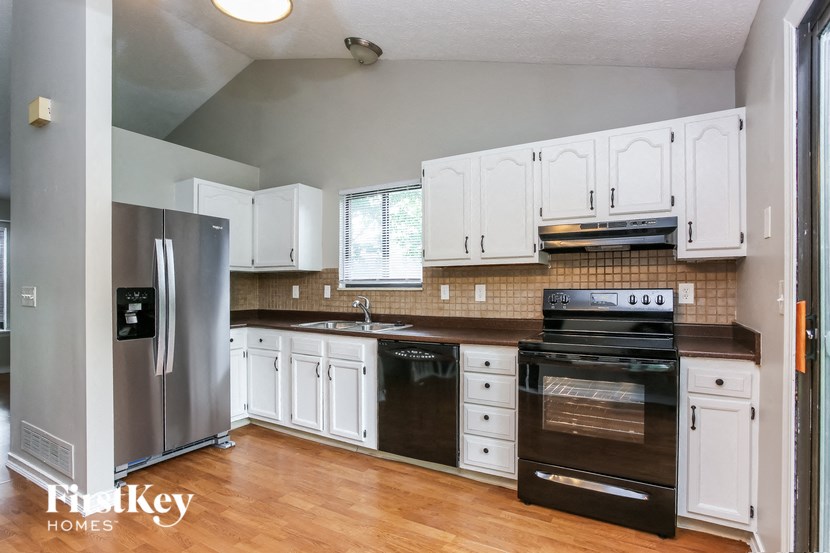 a kitchen with white cabinets and stainless steel appliances