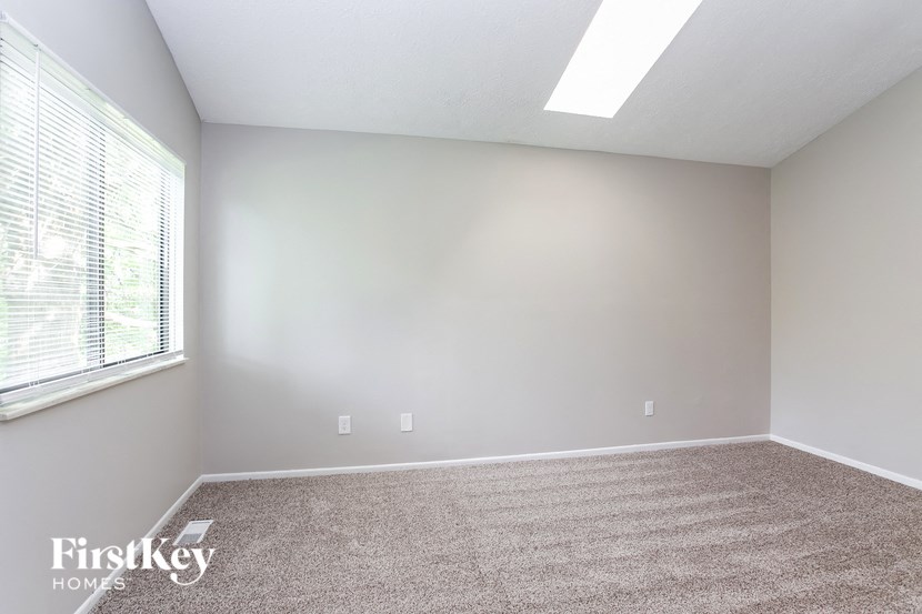 an empty room with carpet and a large window