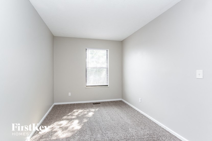 an empty room with carpet and a window