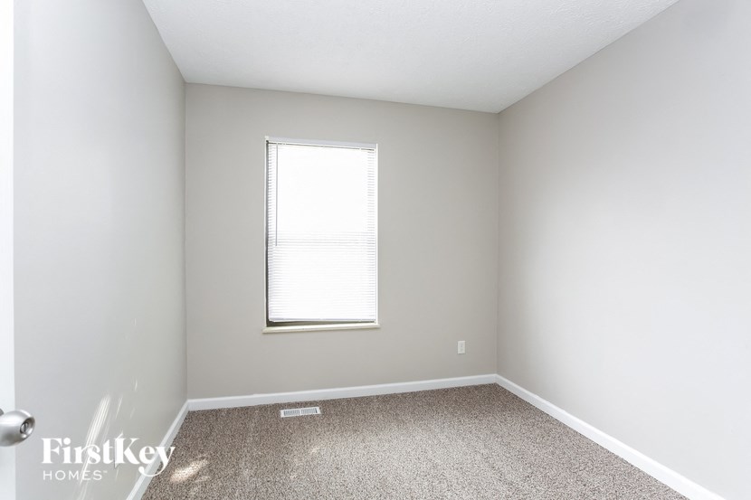 a empty room with a window and a carpet