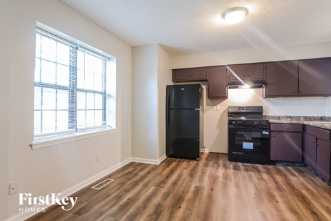 A kitchen area with a black fridge and a black oven.