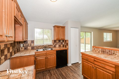 A kitchen with wooden cabinets and a tiled backsplash.