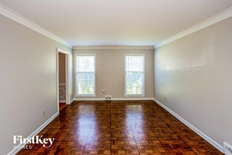 an empty living room with wood floors and windows