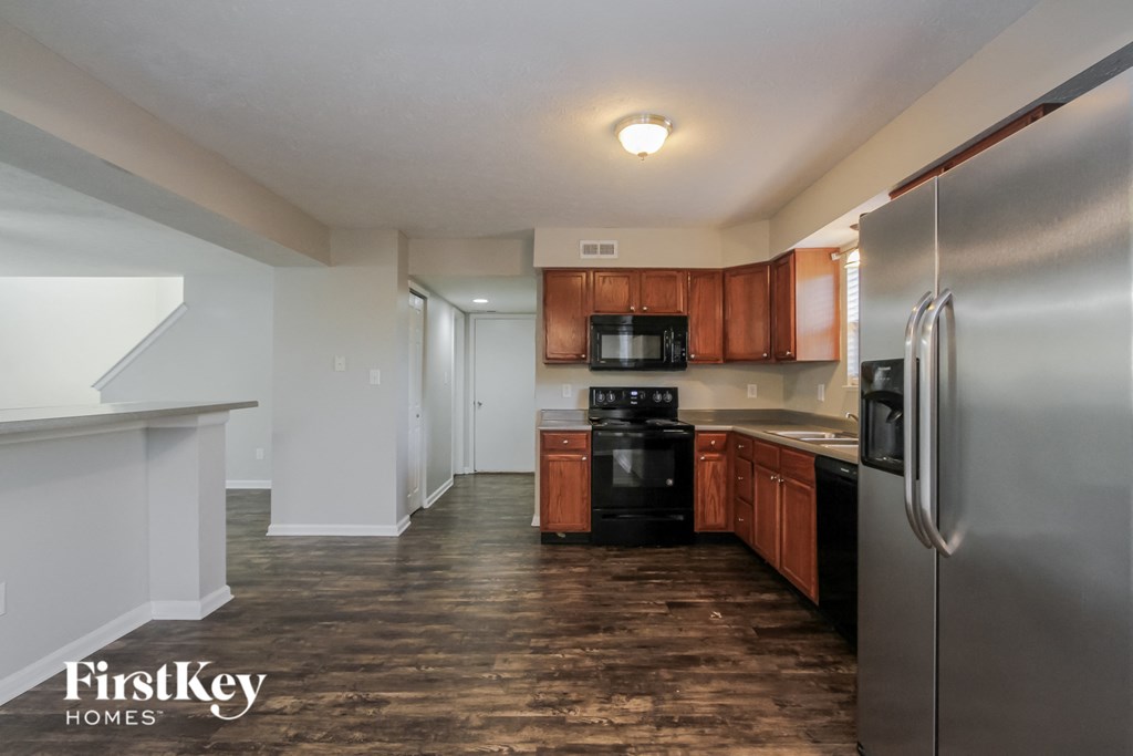 A kitchen with wooden floors and stainless steel appliances.