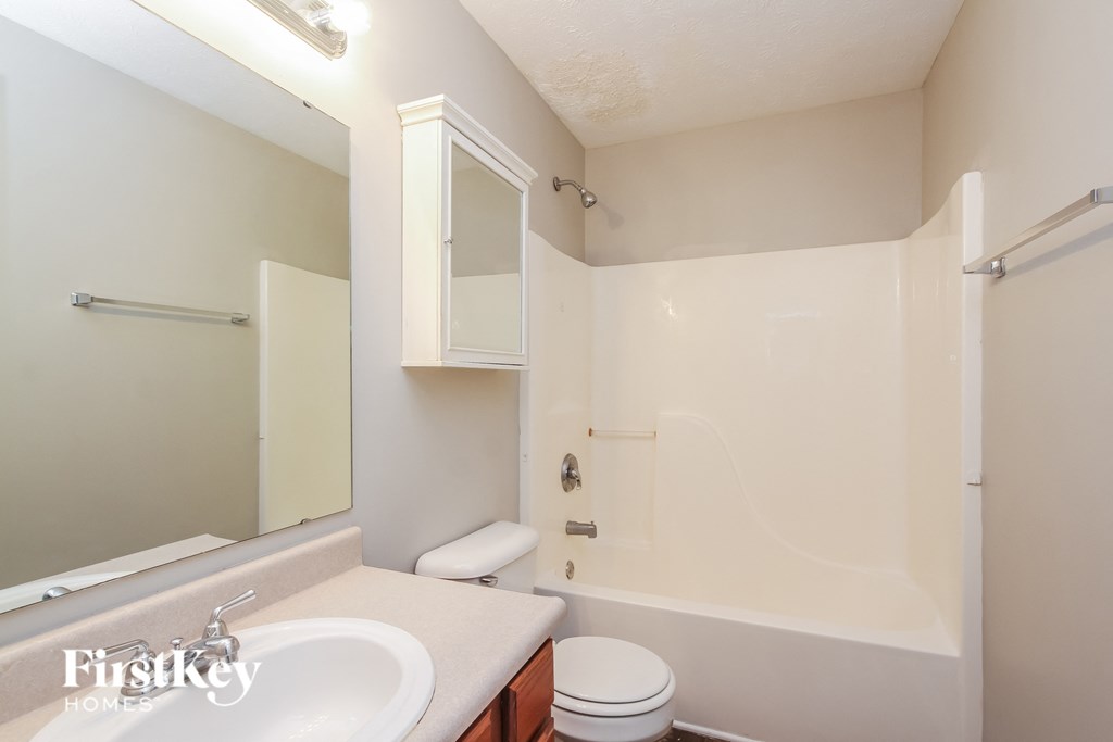 A white bathroom with a sink, toilet and bathtub.