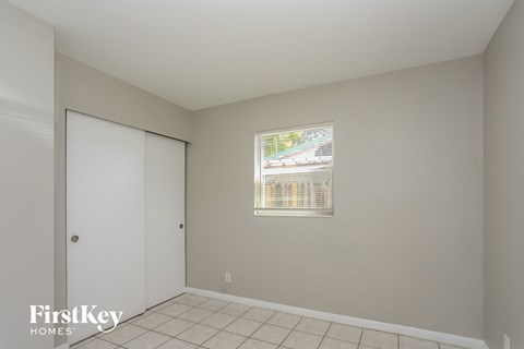 a bedroom with a door to a closet and a window