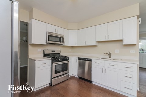 a kitchen with white cabinets and stainless steel appliances