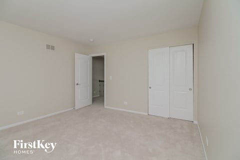 a bedroom with two closets and a door to a hallway