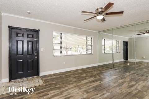 the living room has a large mirror and a ceiling fan