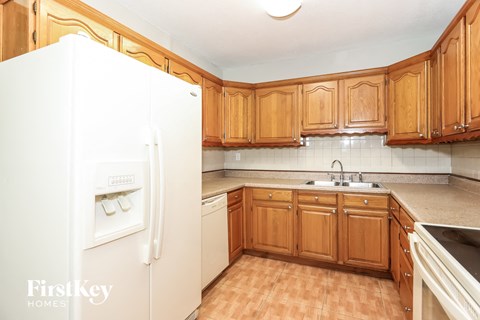 a kitchen with wooden cabinets and a white refrigerator